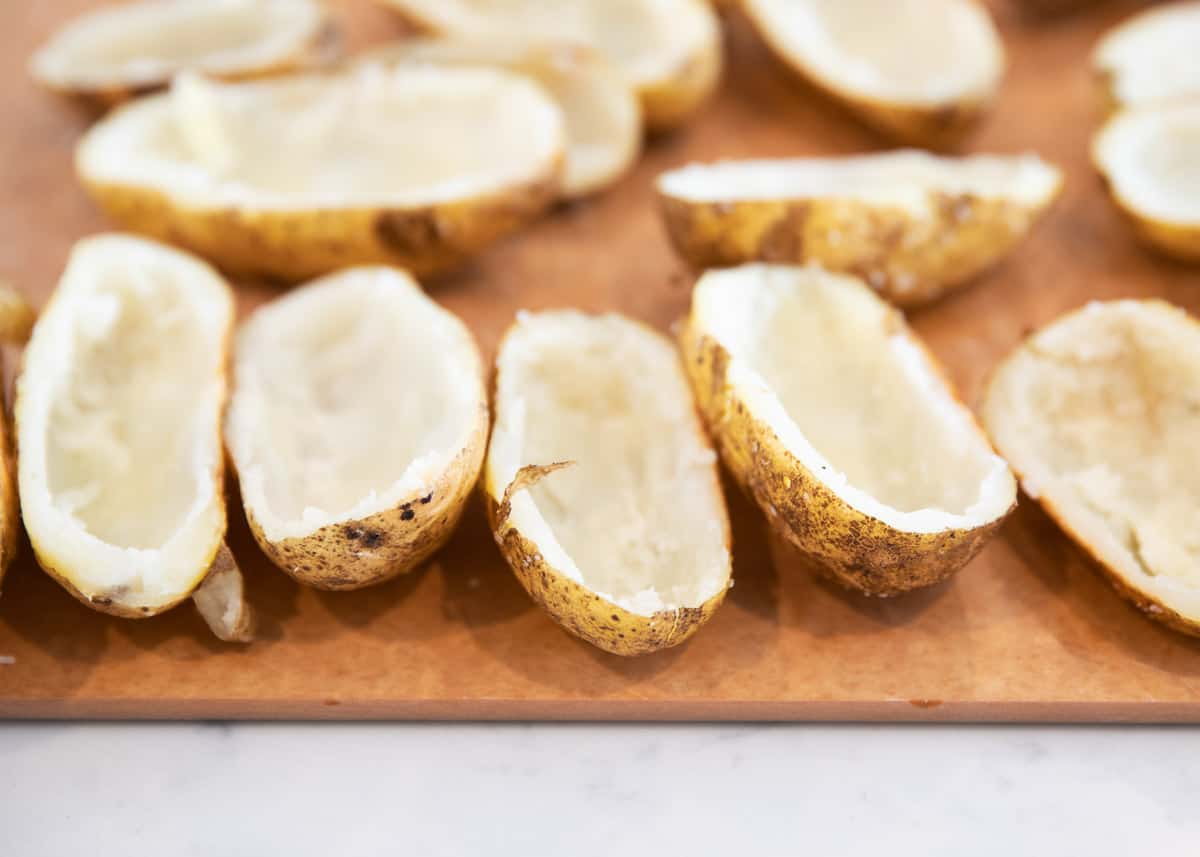 Baked potato shells on cutting board.