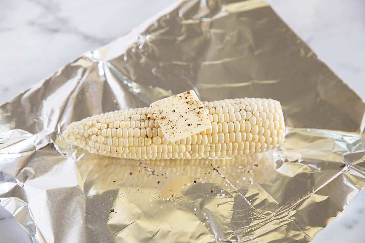 Corn in foil with a pat of butter. 