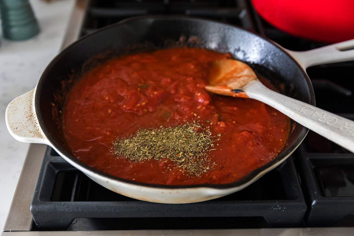 Crusted tomatoes and oregano in skillet.