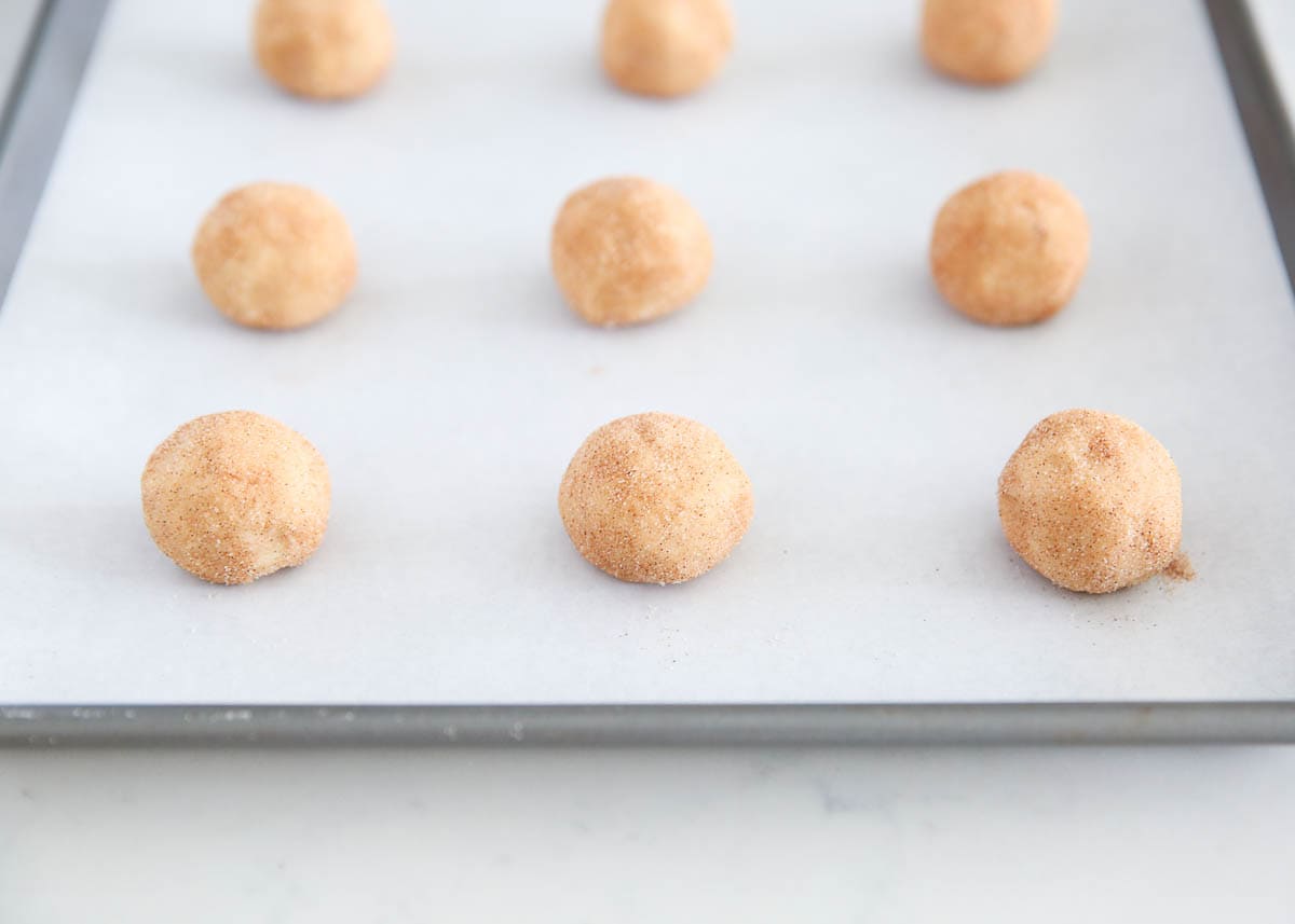 Snickerdoodle cookie dough balls on baking sheet.