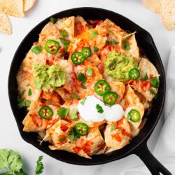 Oven baked nachos in a cast iron skillet.