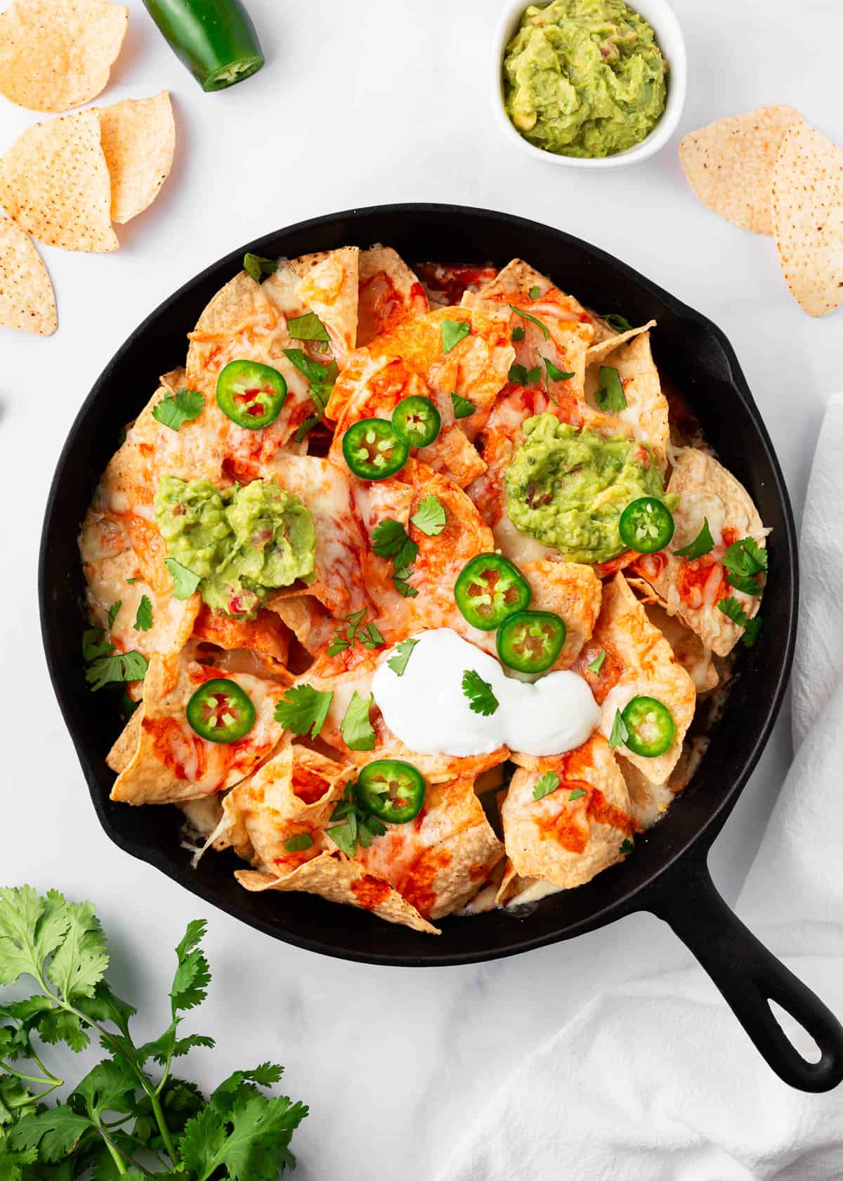 Oven baked nachos in a cast iron skillet.