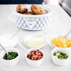 baked potato bar toppings in white bowls