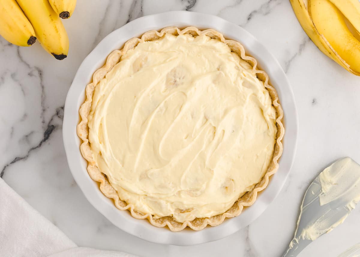 spreading banana cream pie mixture into pie crust