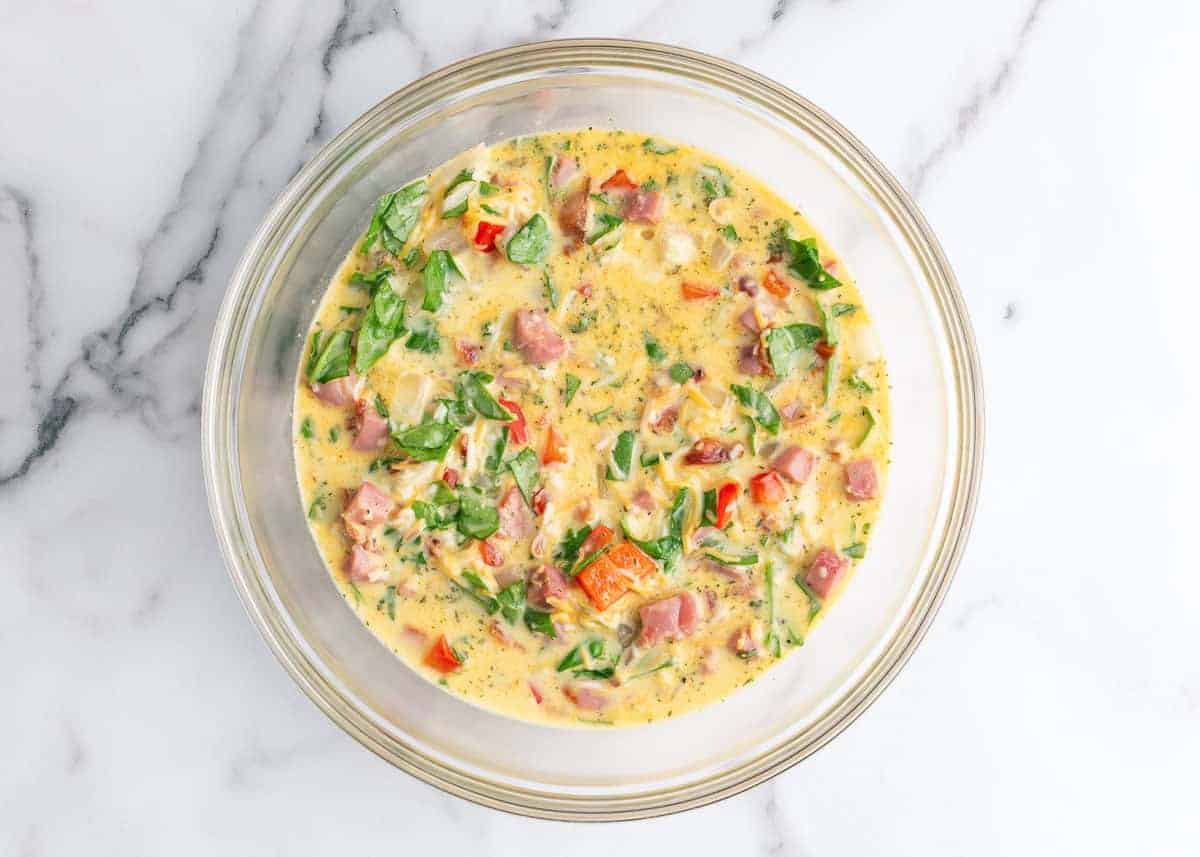 Egg mixture for breakfast pie in a bowl.