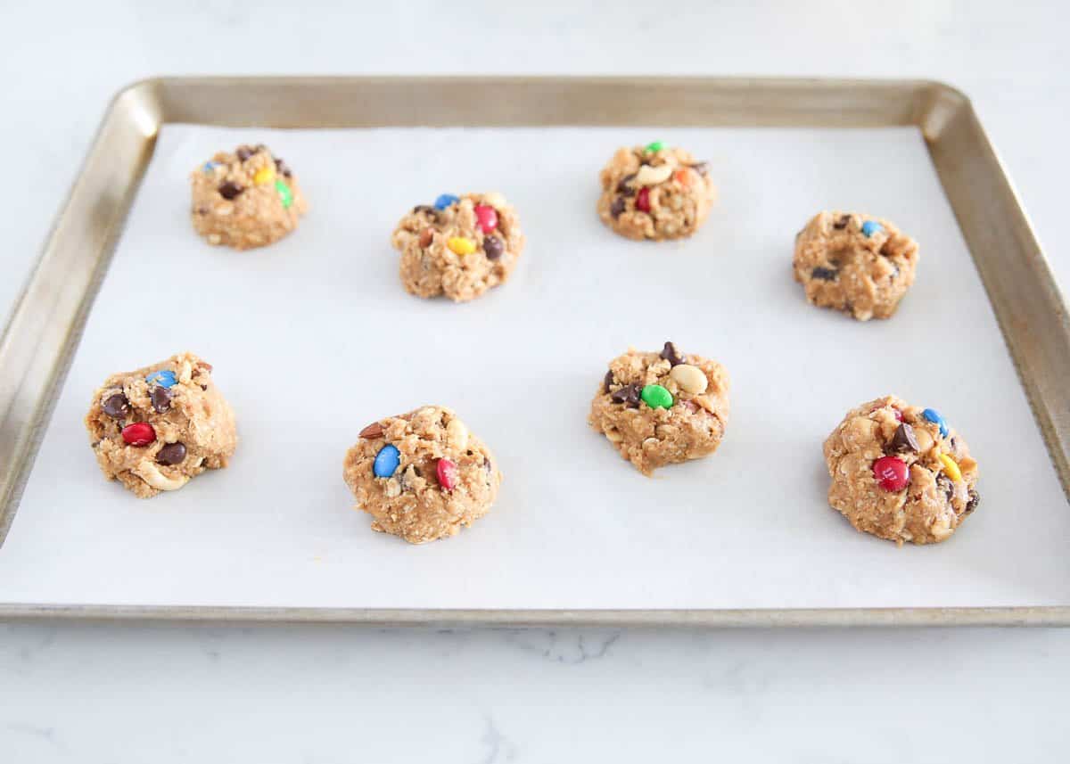 Trail mix cookie dough balls on baking sheet.