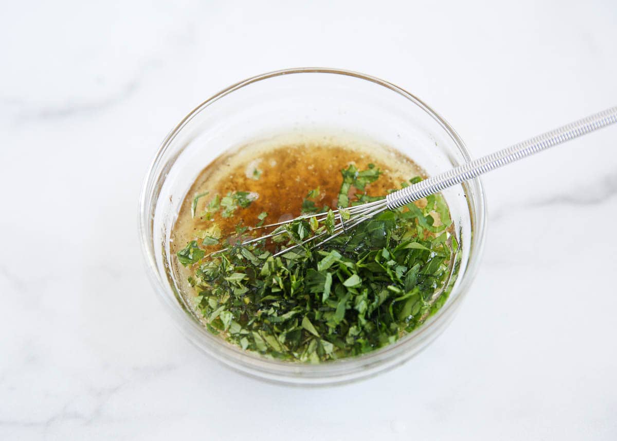 Greek chicken marinade in a small bowl with whisk.