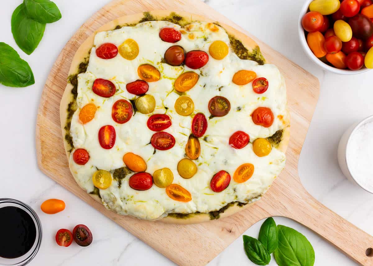 Caprese pizza on pizza peel after baking.