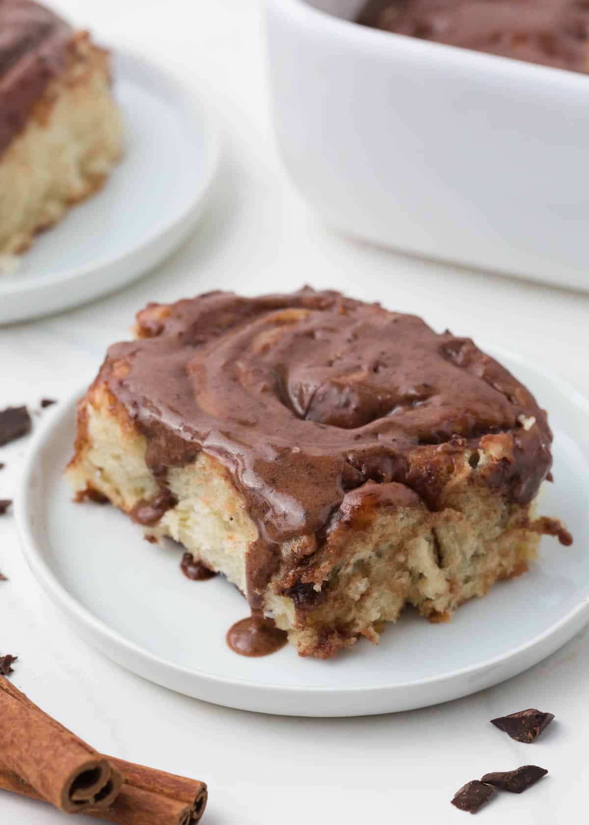 Chocolate cinnamon roll on a white plate.