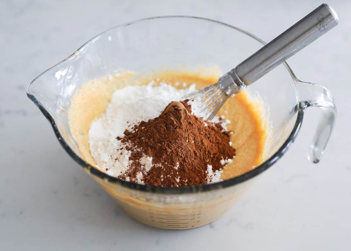 A bowl with pumpkin waffle batter, flour and pumpkin pie spice.