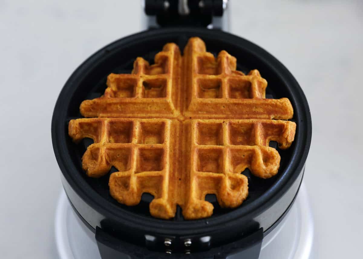 Making a pumpkin waffle in a waffler maker.