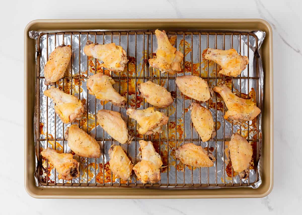 Crispy oven baked teriyaki chicken wings on wire rack.