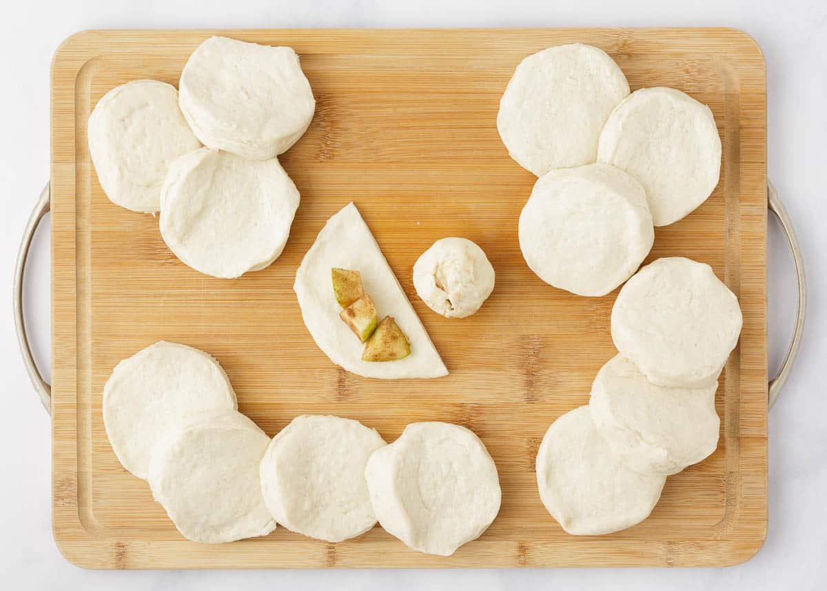 Biscuits on a cutting board, showing how to fold apple mixture into the dough.