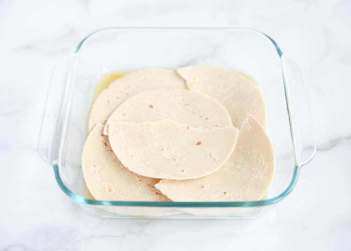 Layering tortillas in a baking dish.