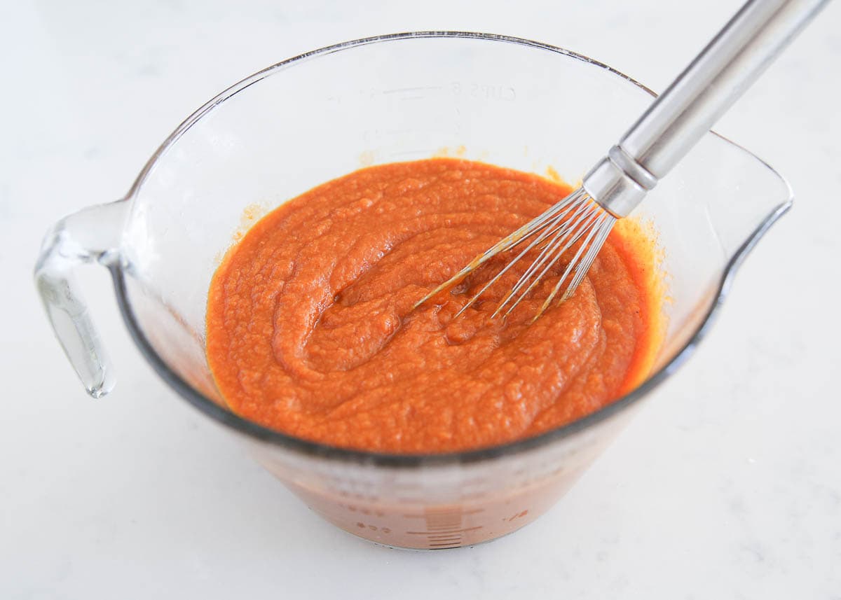 Pumpkin puree in a bowl with whisk. 