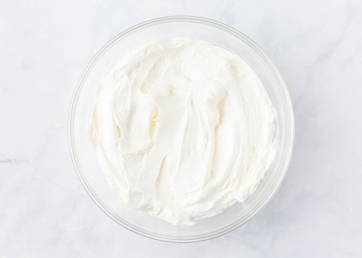 Cream cheese, sugar and Cool whip combined in a bowl.