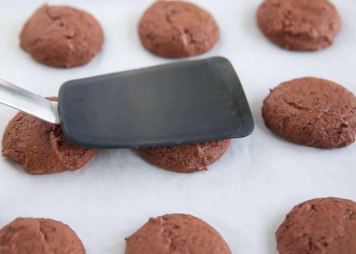 Flattening cookie dough balls with a spatula.