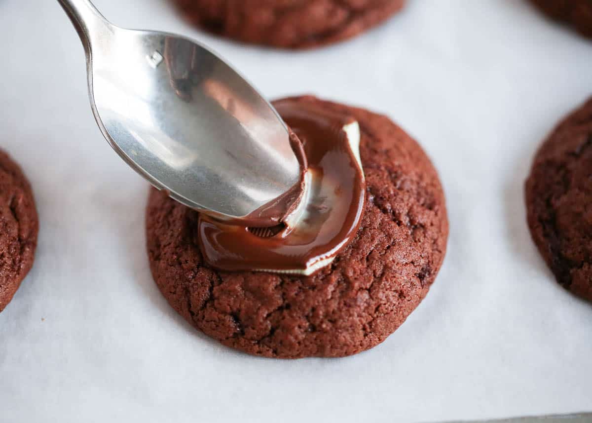 Adding an Andes mint on top of a chocolate cookie.