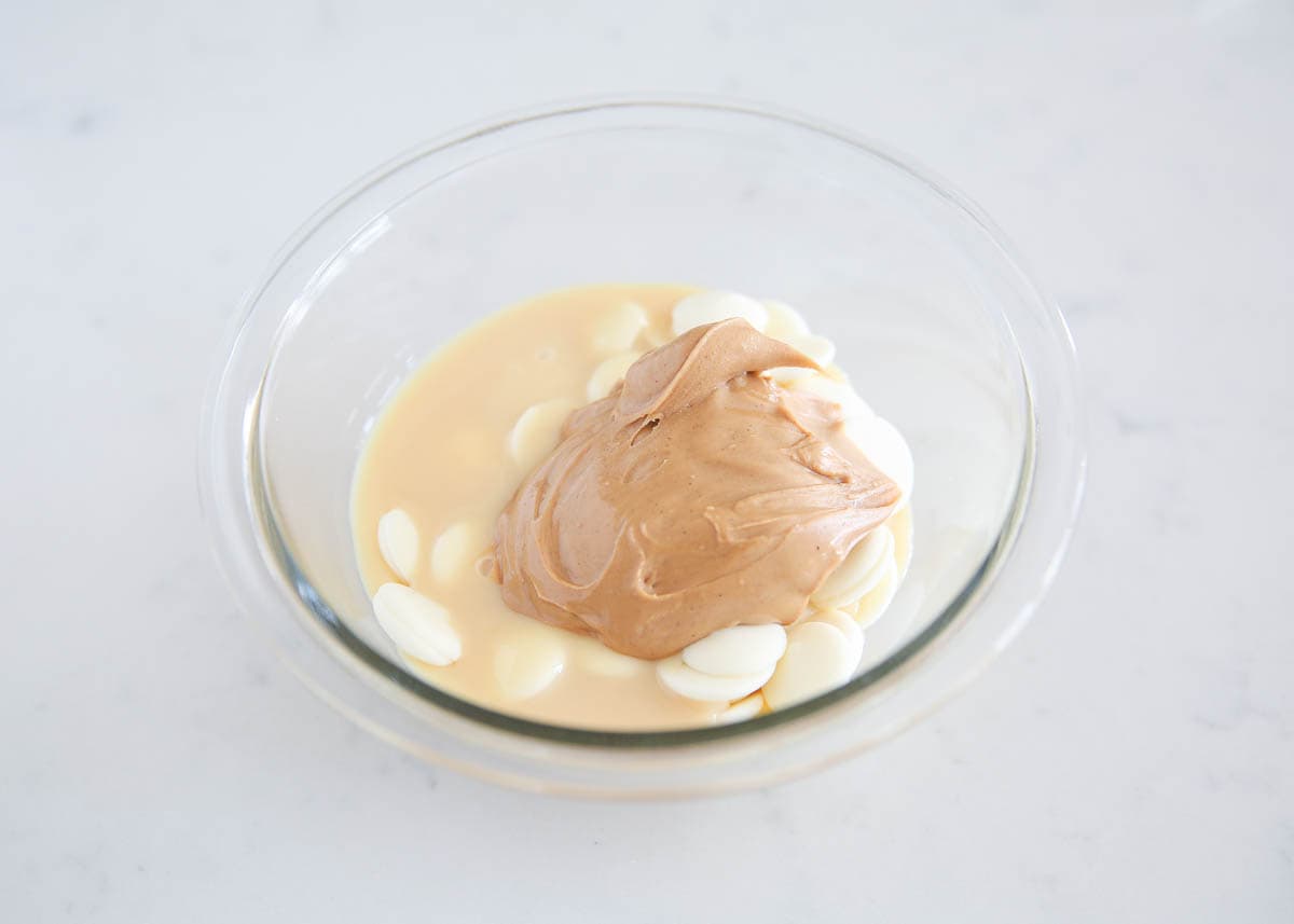 Peanut butter in bowl with white chocolate and sweetened condensed milk.