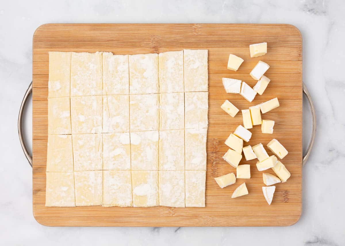 Puff pastry cut into strips and brie cut into cubes.