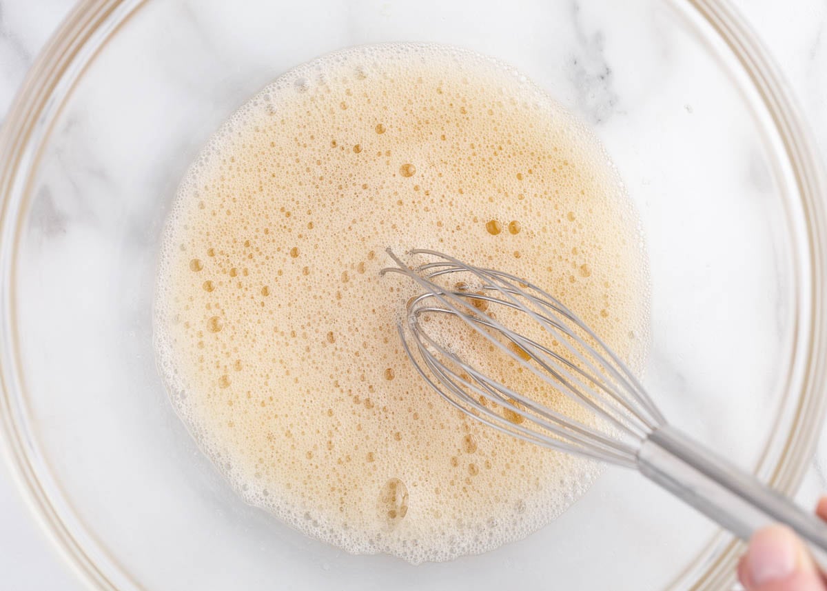 Egg whites being whisked in a bowl.