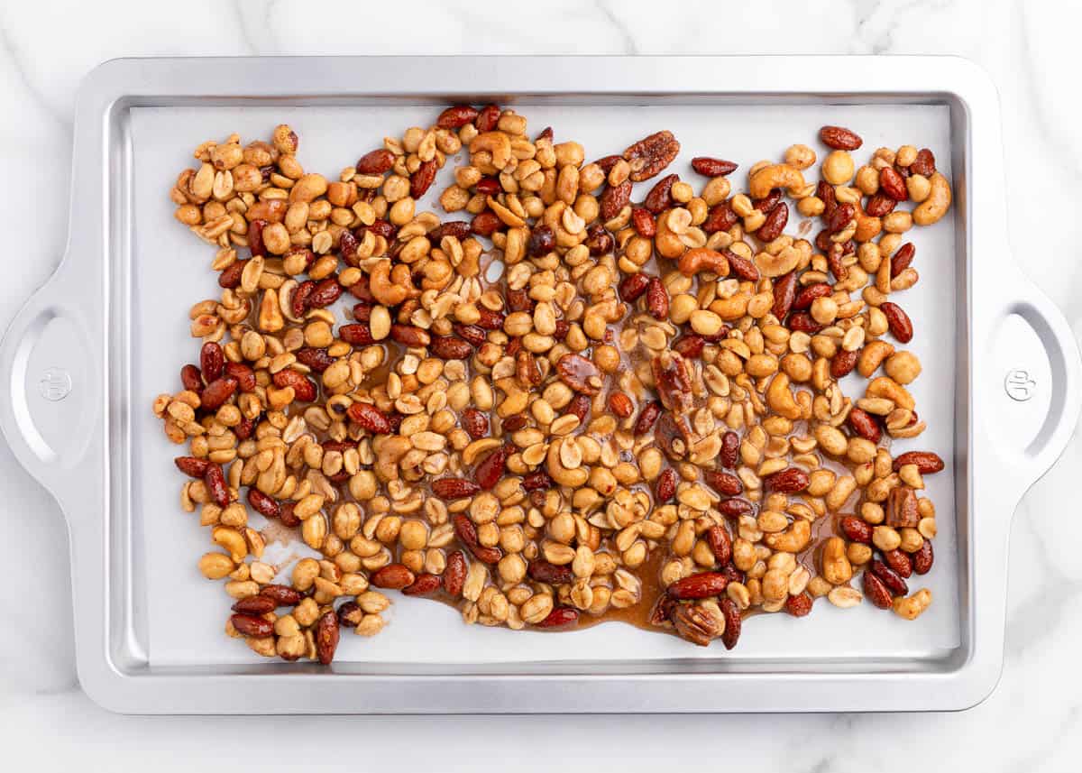 Mixed candied nuts on a baking sheet.