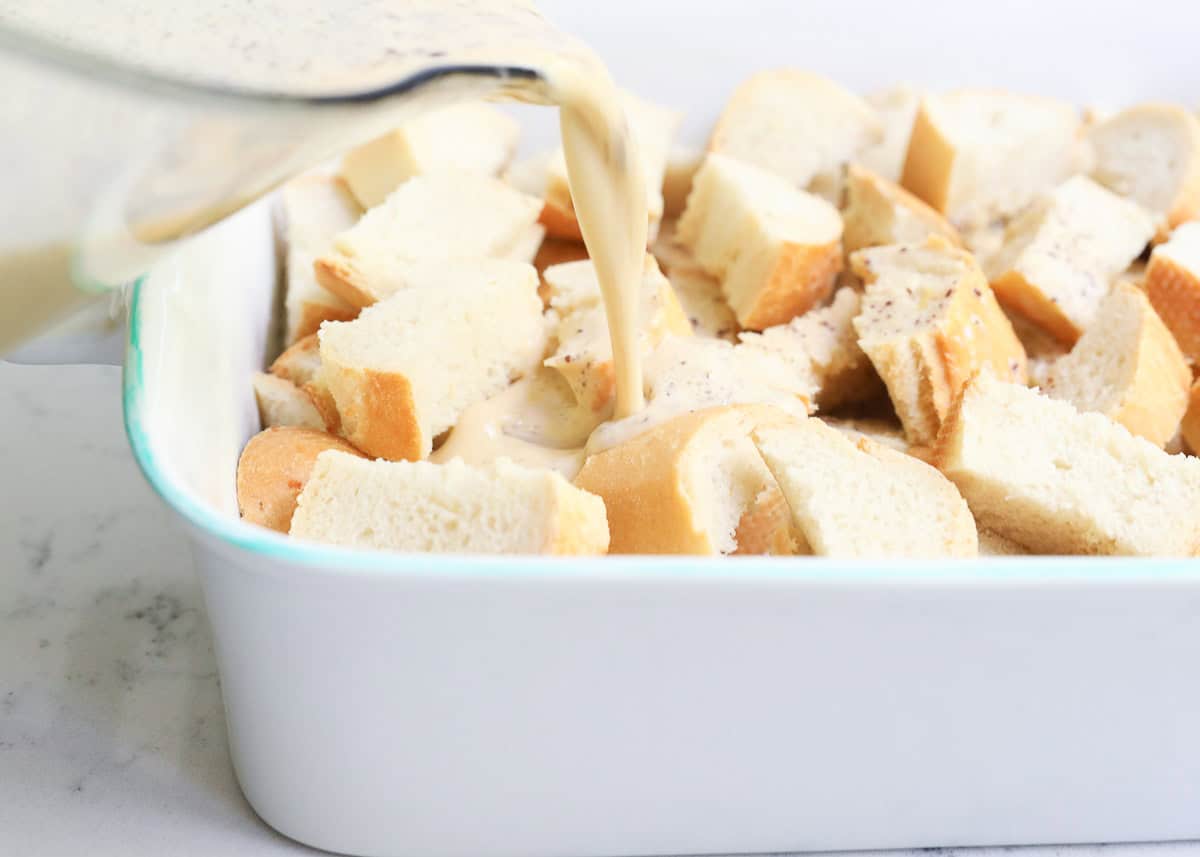 Bread cubes in baking dish and pouring custard mixture over it.