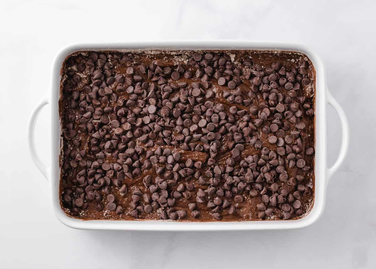 Chocolate chips on top of unbaked chocolate dump cake.