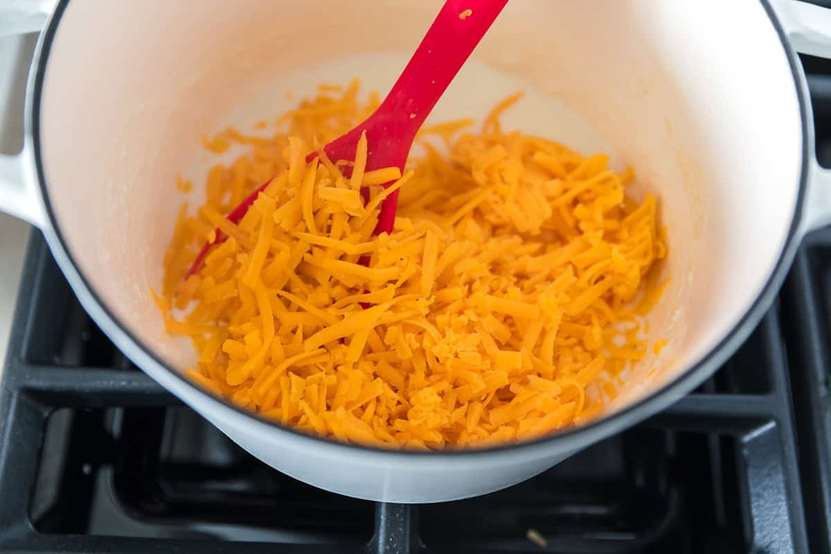 Adding shredded cheese for pretzel cheese sauce.