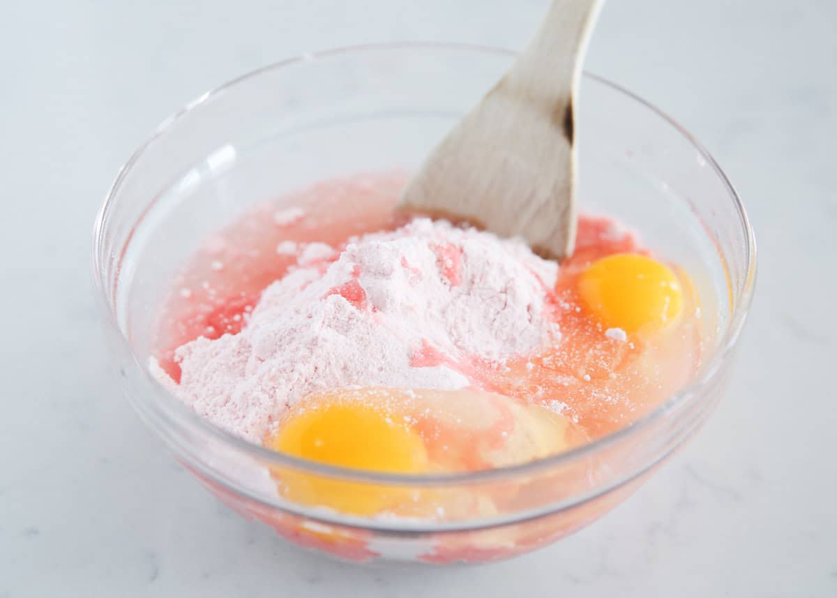 Eggs, oil and strawberry cake mix in a bowl.