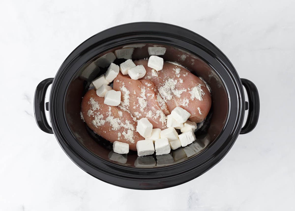 Raw chicken, ranch and cream cheese in crockpot.