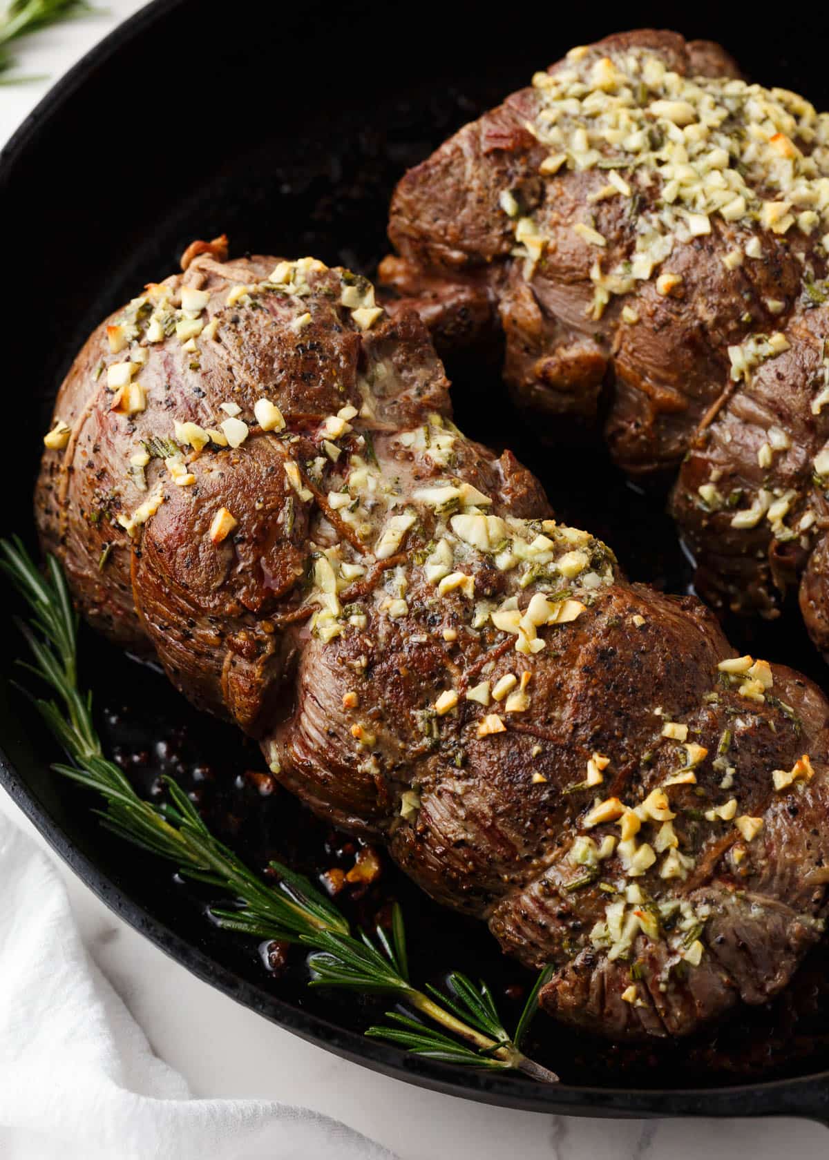 Beef tenderloin in a cast iron skillet.