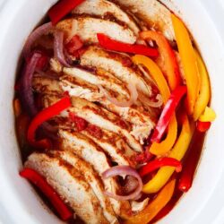 Crockpot chicken fajitas in a white pot.