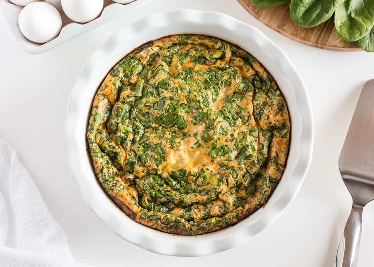 Baked crustless quiche in a white baking dish.