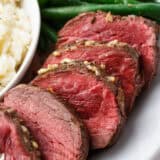 Sliced beef tenderloin on a white plate.