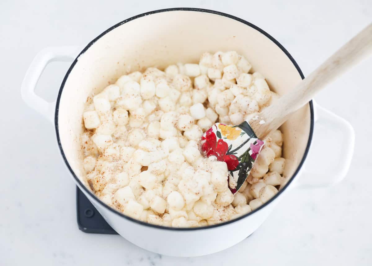 Marshmallows being added to a pot on the stove.