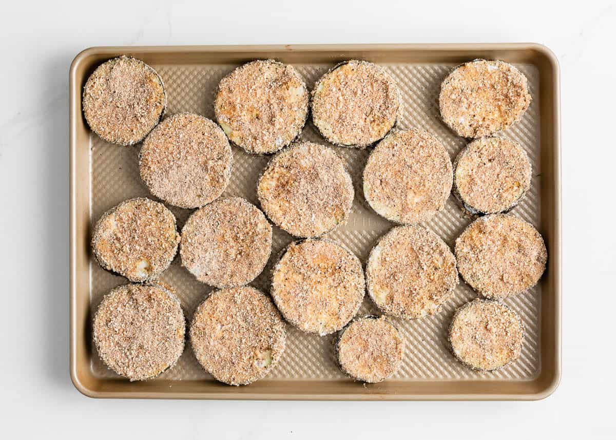 Breaded eggplant on baking sheet.