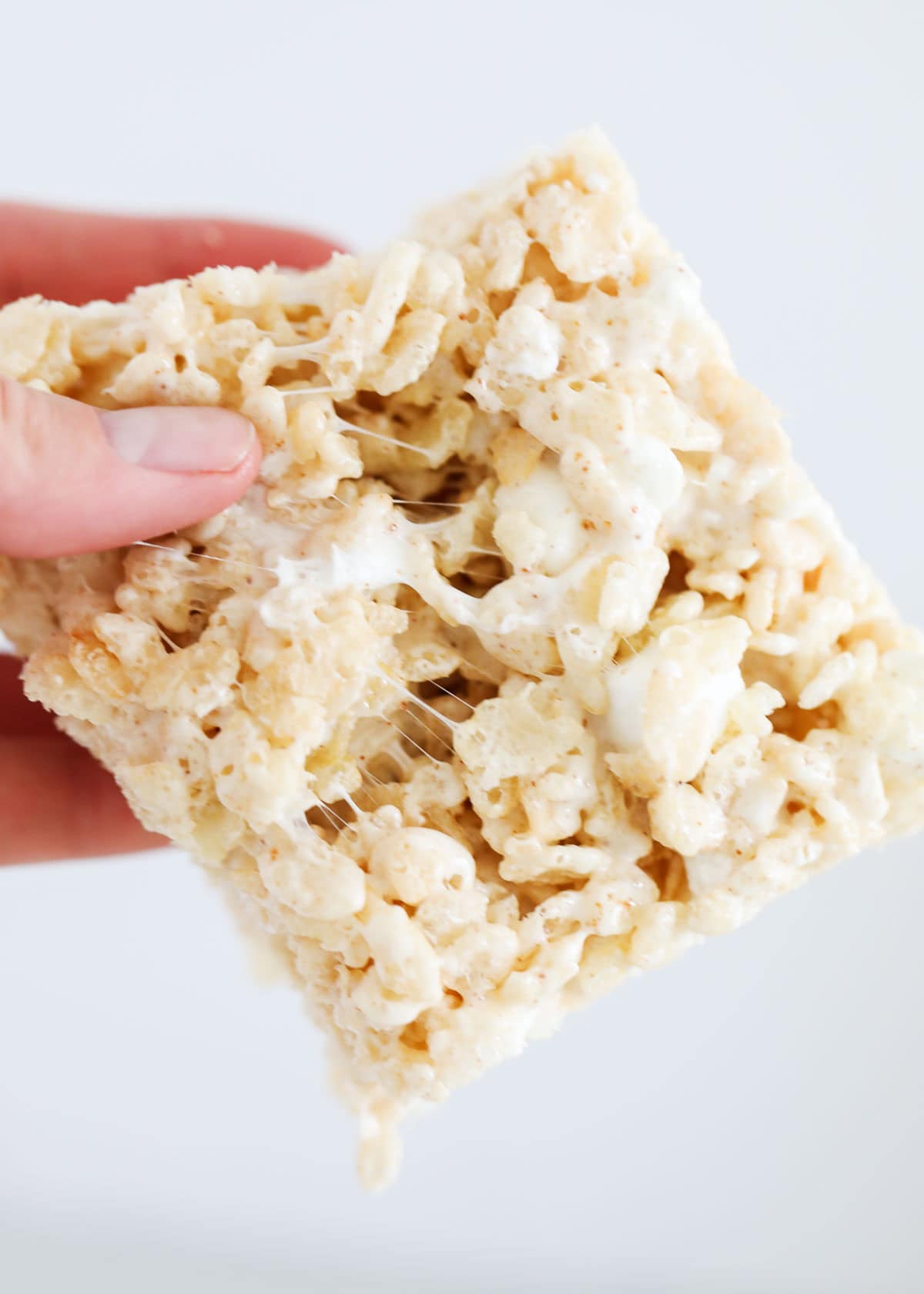 A hand holding a brown butter rice krispie treat.