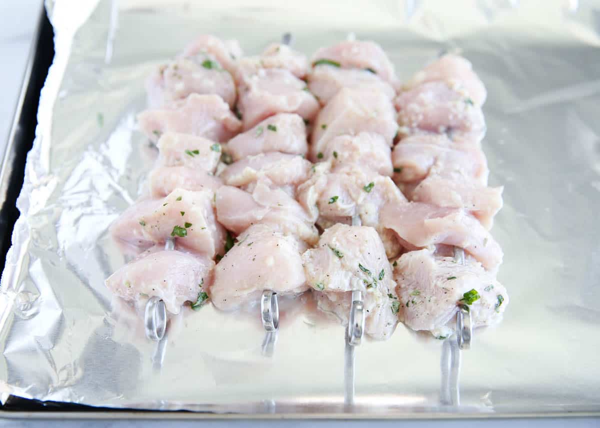 Chicken threaded onto skewers.