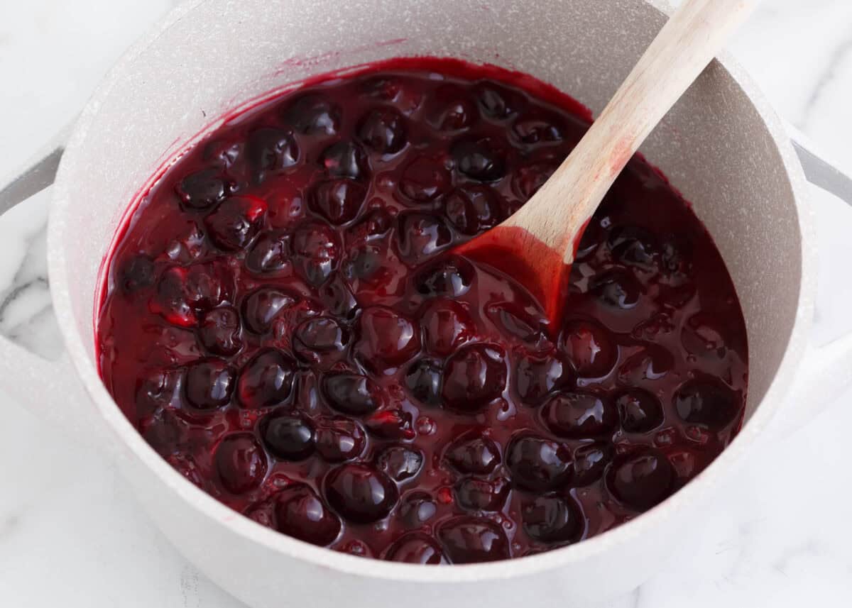 Making cherry pie filling in a stove pot.