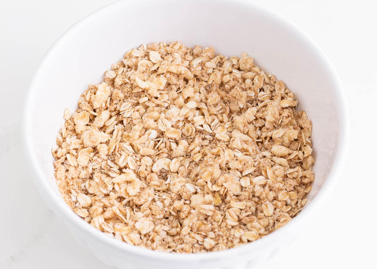 Oat topping for peach crisp in a white bowl.