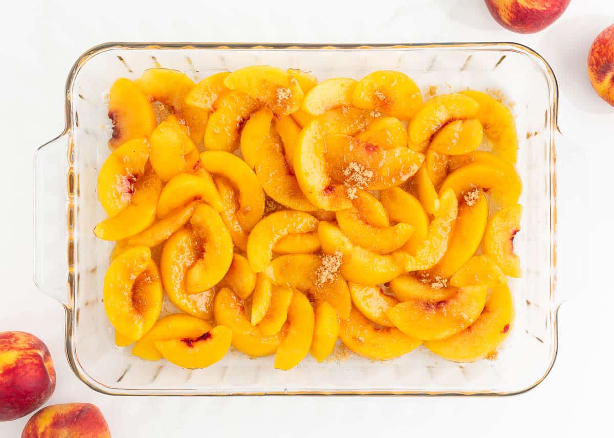 Sliced peaches in baking dish.