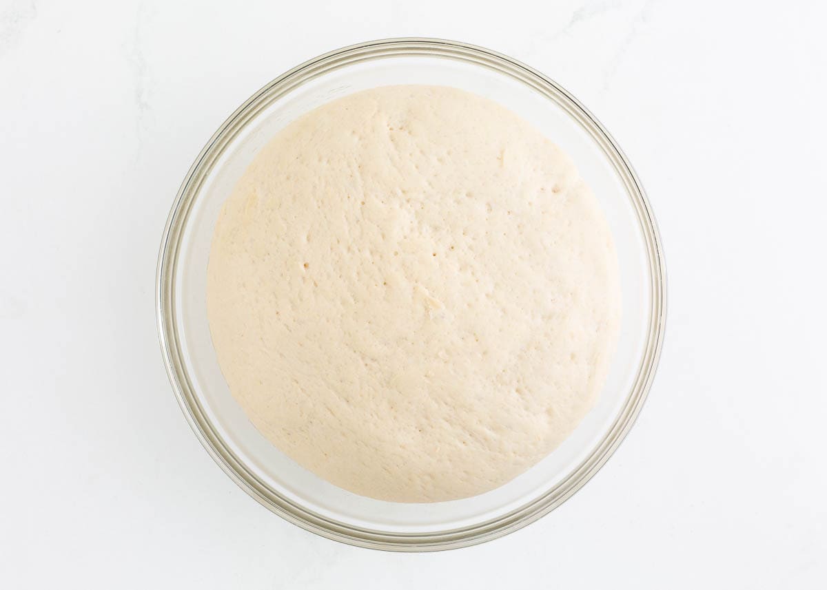 Beignet dough in a glass bowl.