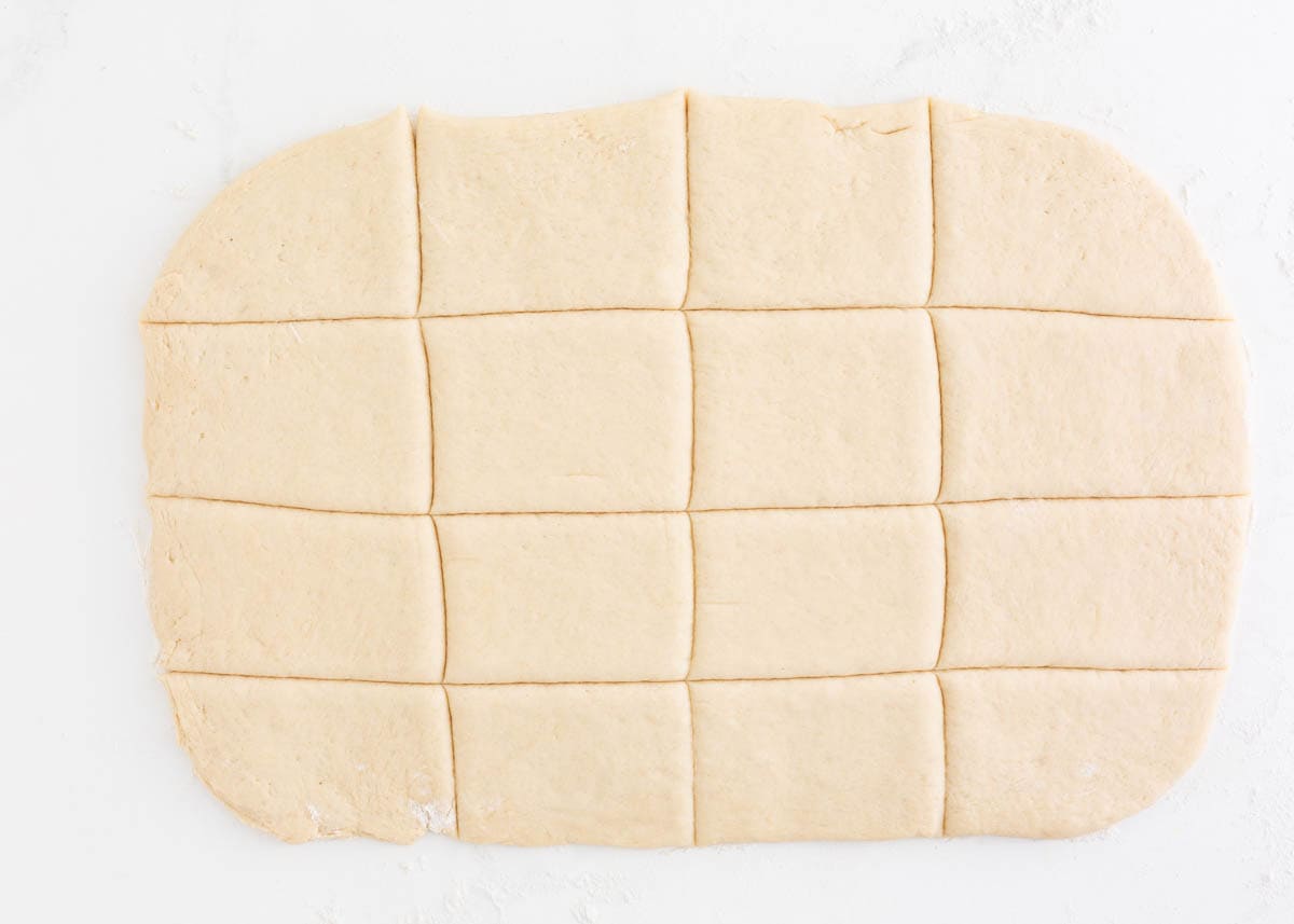 Beignet dough rolled out and cut into squares.