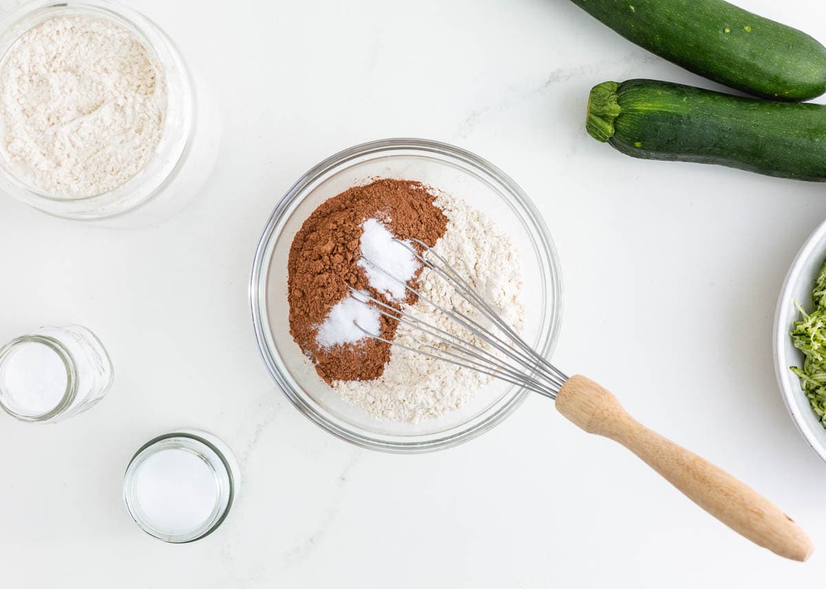 Whisking flour, cocoa powder and baking soda in a bowl.