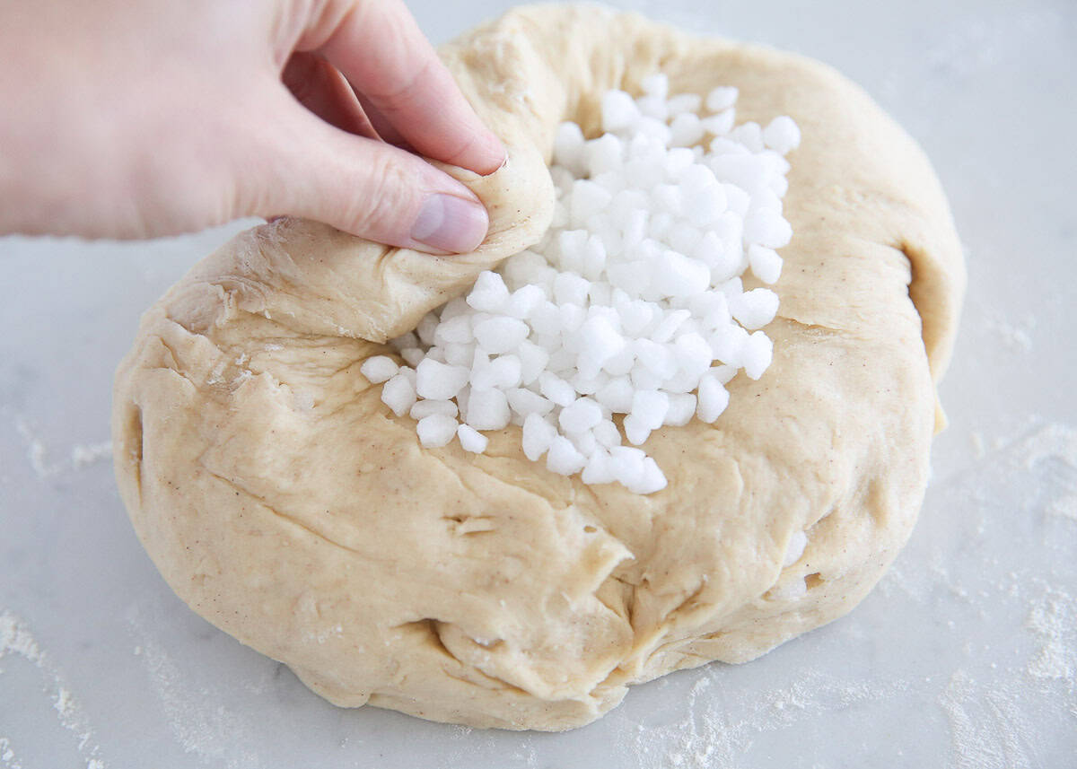 Showing how to fold pearl sugar into liege waffle dough.