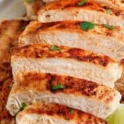 A piece of sliced grilled chicken with a lime wedge.