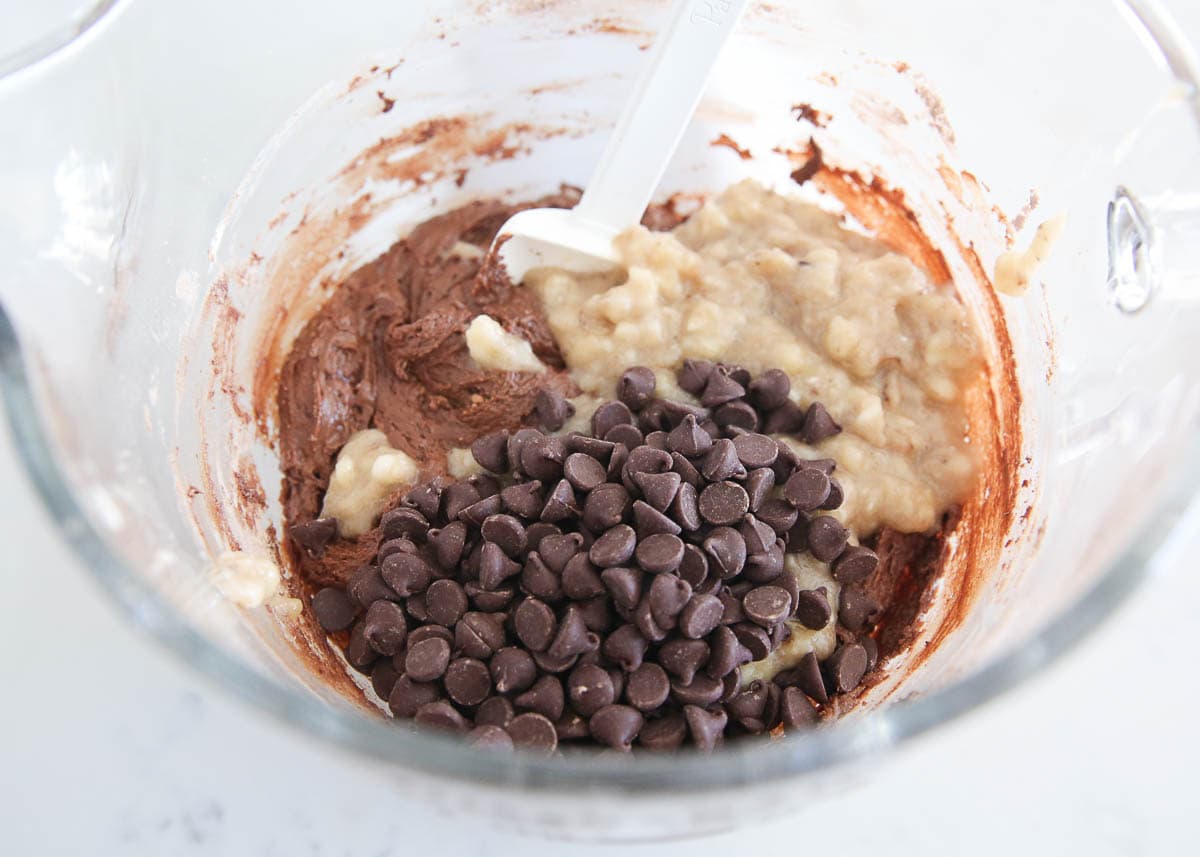 Adding bananas and chocolate chips to double chocolate banana bread batter. 