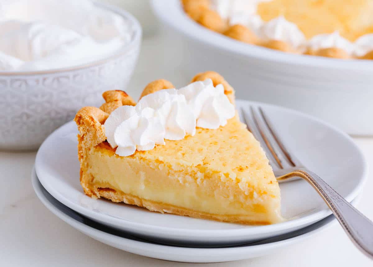 A slice of buttermilk pie on a white plate.