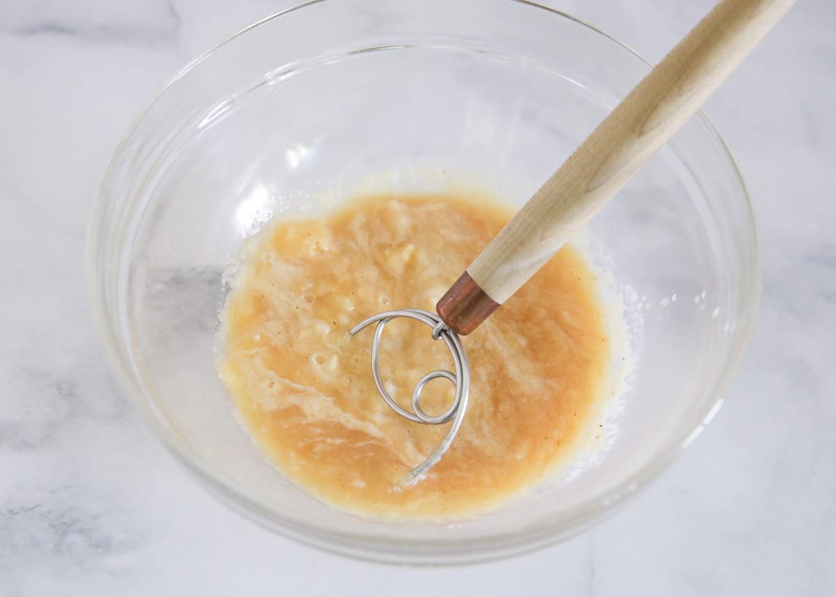 Mashing banana with applesauce in a bowl.